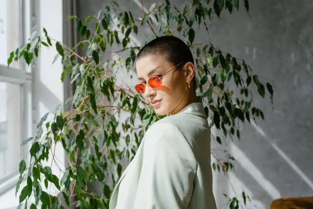 Persona con corte buzz cut reciente bajo la luz del sol de verano en ambiente urbano