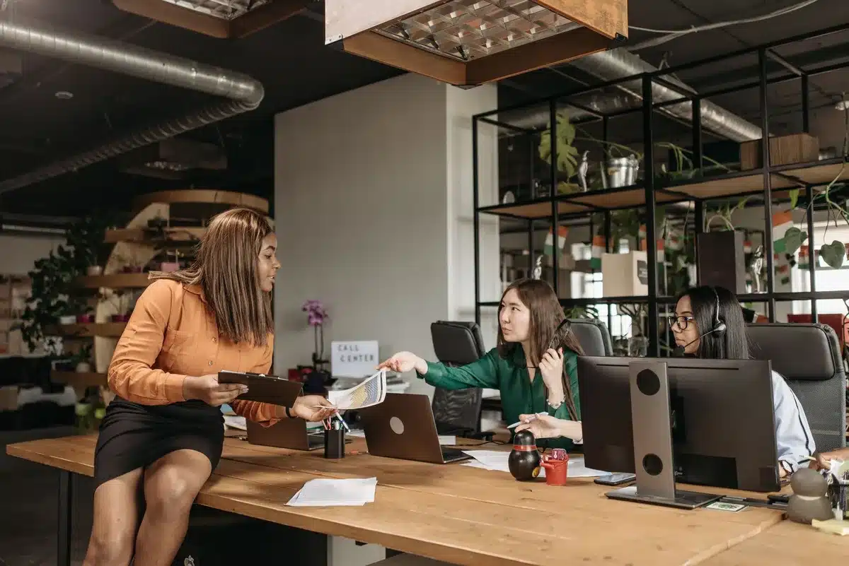 Mujeres profesionales colaborando alrededor de una mesa de conferencias en una oficina moderna y bien iluminada.
