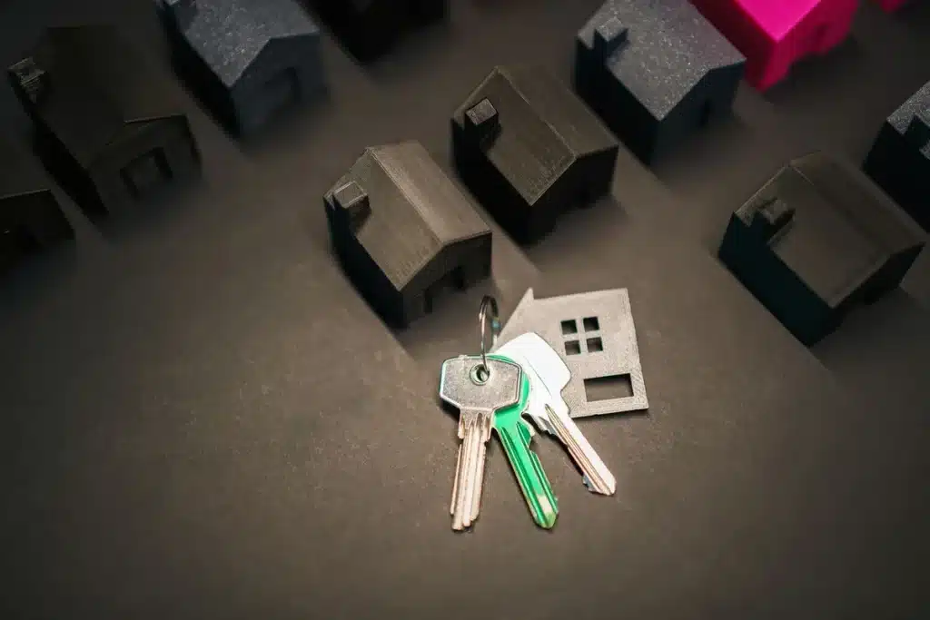 Manos anónimas sostienen llaves de apartamento con horizonte de ciudad moderna de fondo