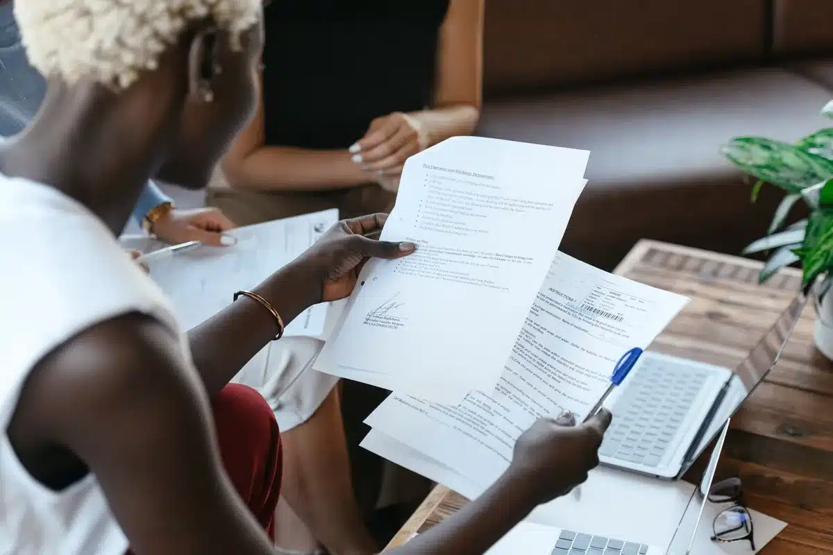 Trabajadores comparando rendimientos y costos de diferentes fondos de pensiones en documentos