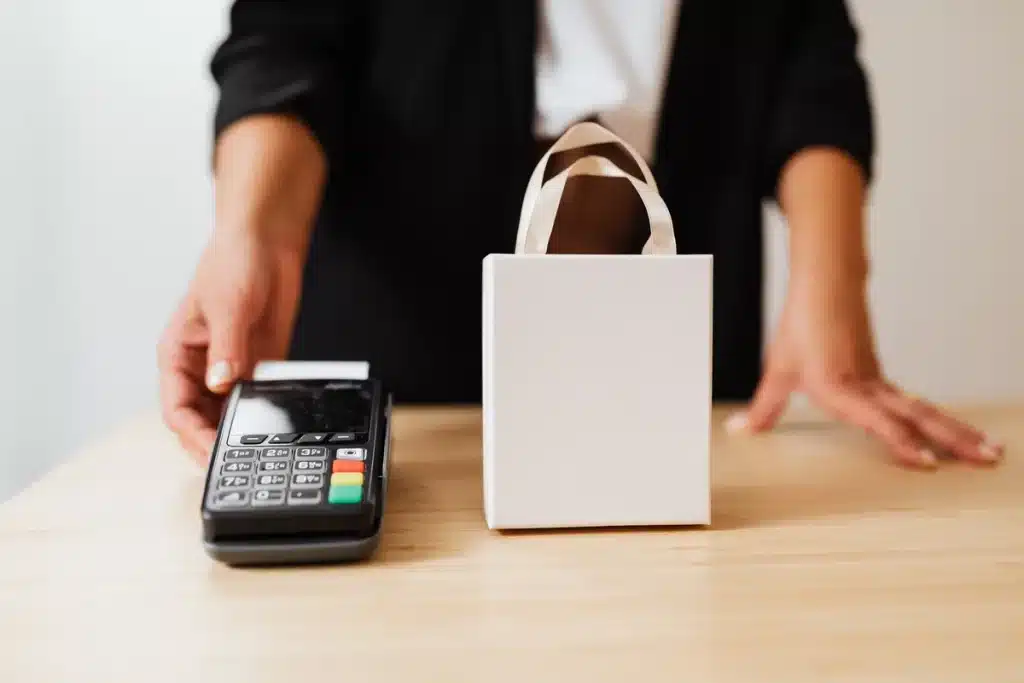 Manos realizando pago en efectivo en caja de tienda de descuentos sin tarjeta