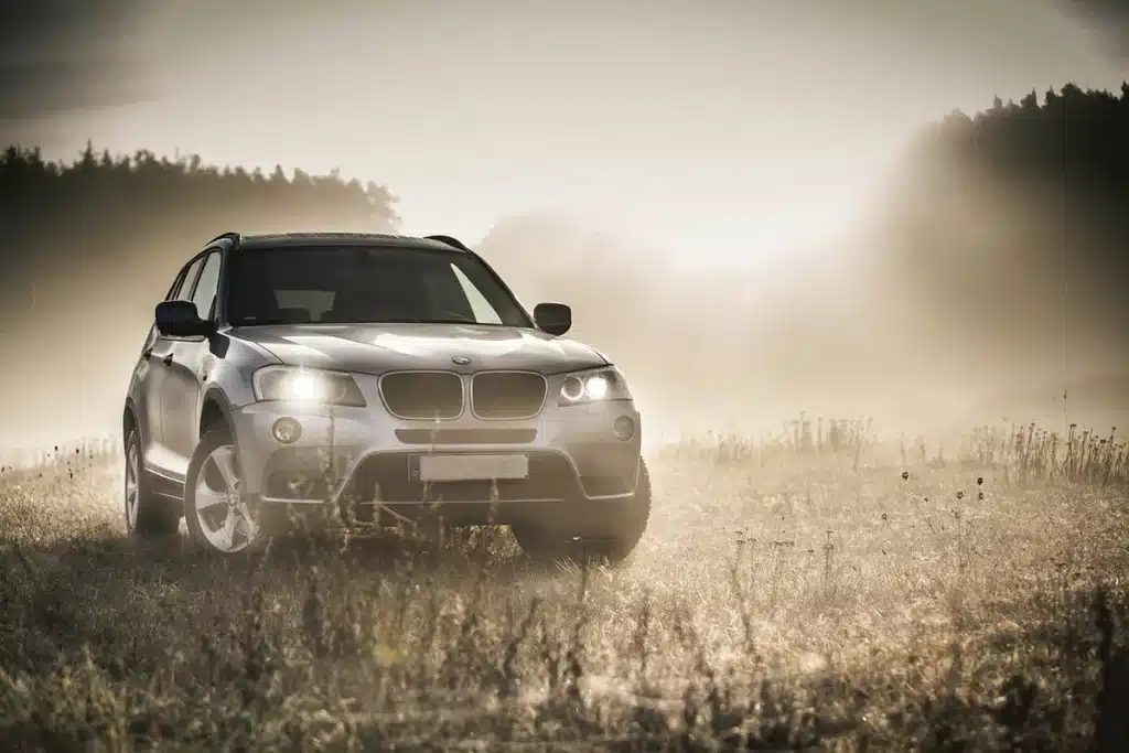 SUV eléctrica conectada a un cable de carga con herramientas de construcción al fondo