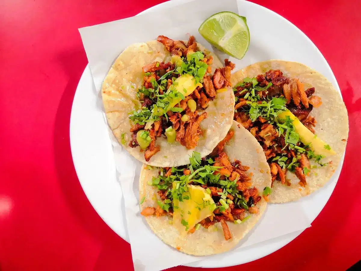 Puesto callejero de tacos en la Ciudad de México con clientes esperando