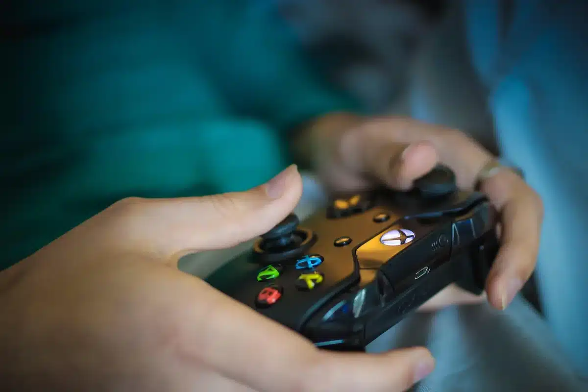 empty staging area with two anonymous gaming devices on a table, soft studio light, one device showing a glowing abstract HUD