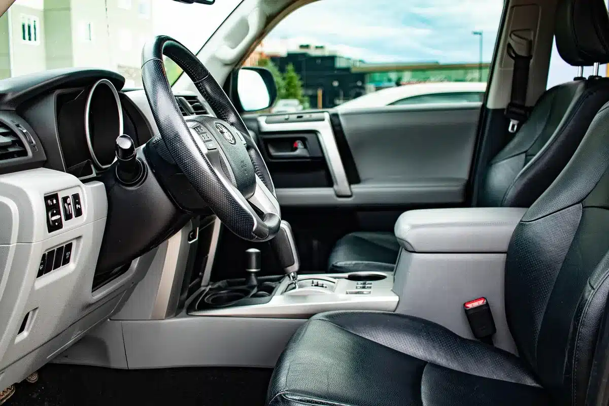 Interior view of a large unbranded SUV cabin showing a wide digital instrument cluster and central touchscreen, seats folded, anonymous setting