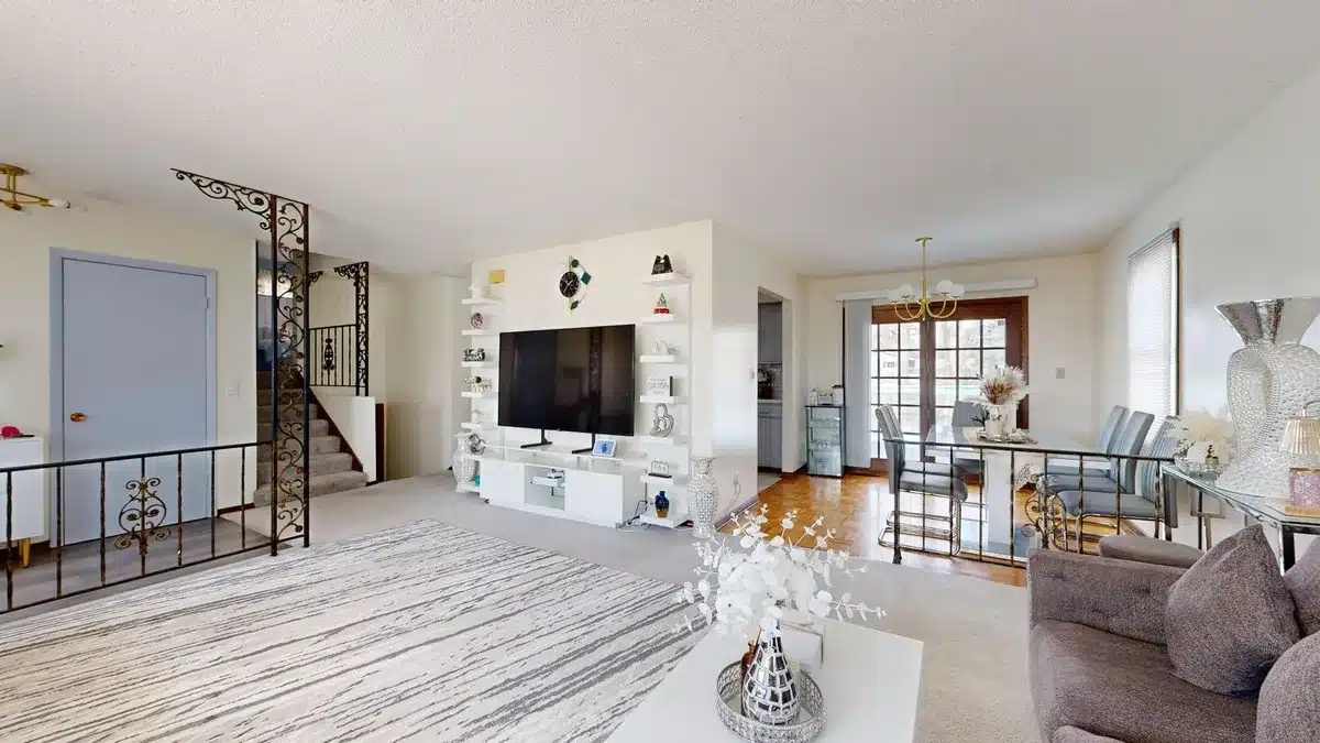 Empty living room with a large unbranded 55-inch TV on a low console, soft evening light, remote on a coffee table