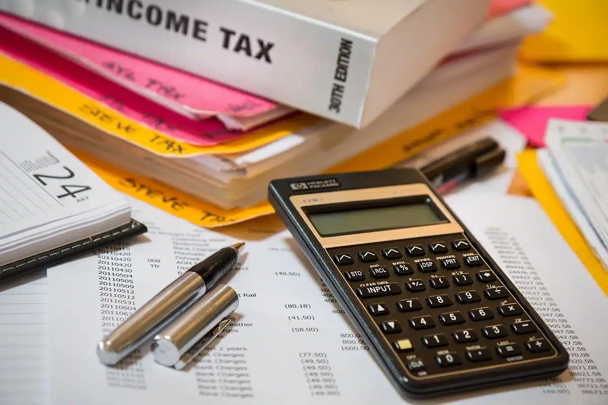 Calculadora y papeles de presupuesto público que ilustran presión fiscal por pensiones