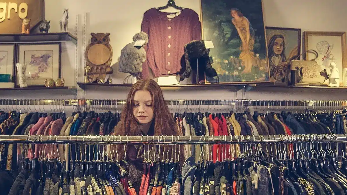Clientes en centro comercial viendo escaparates y entrando a tiendas de moda