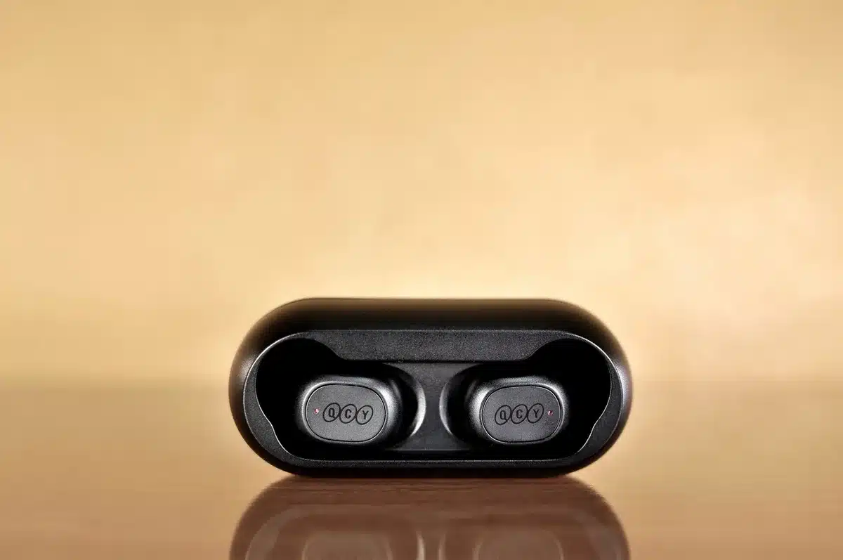 Open-ear clip earbuds on a running armband, no logos, studio light