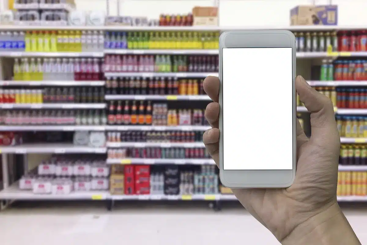 A clean mobile shop interior with anonymous staff stocking SIM cards on shelves and a digital display, no logos, daytime storefront
